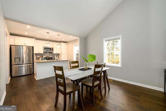 dining room with high vaulted ceiling, dark wood-type flooring, baseboards, and recessed lighting