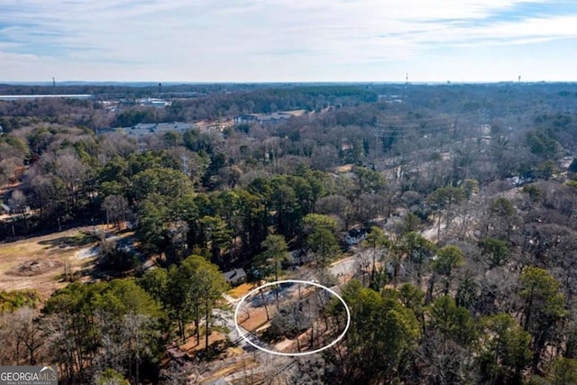 drone / aerial view with a wooded view