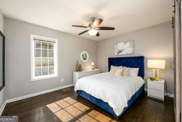 bedroom featuring baseboards, ceiling fan, visible vents, and hardwood / wood-style flooring