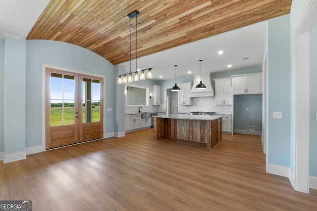 264 Community House Rd, Barnesville, GA 30204 - kitchen with premium range hood, french doors, appliances with stainless steel finishes, white cabinetry, and a kitchen island