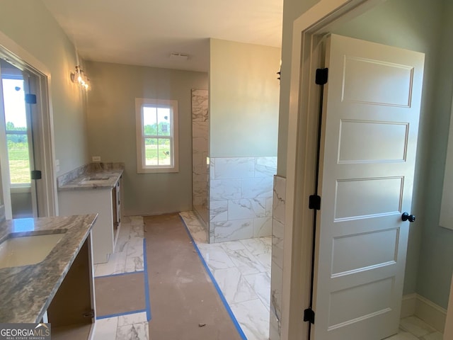 full bathroom featuring vanity, marble finish floor, and walk in shower
