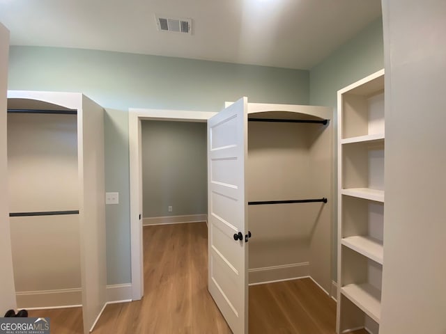 spacious closet featuring visible vents and wood finished floors