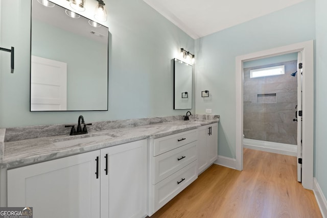 264 Community House Rd, Barnesville, GA 30204 - full bathroom featuring double vanity, wood finished floors, tiled shower, and baseboards