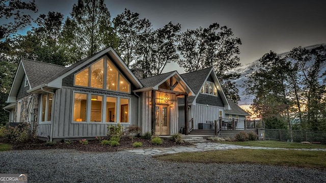 view of front facade featuring a chimney, fence, board and batten siding, and a deck