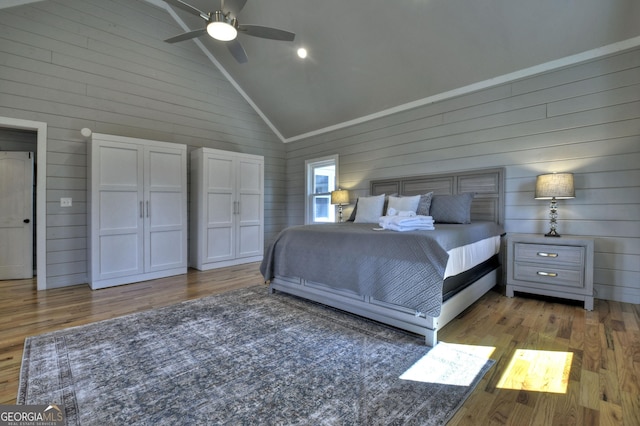 bedroom with a ceiling fan, high vaulted ceiling, and wood finished floors