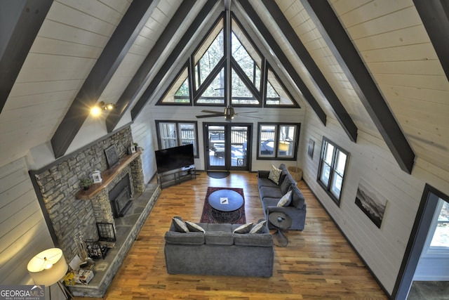 living area with high vaulted ceiling, a fireplace, wood finished floors, beam ceiling, and french doors