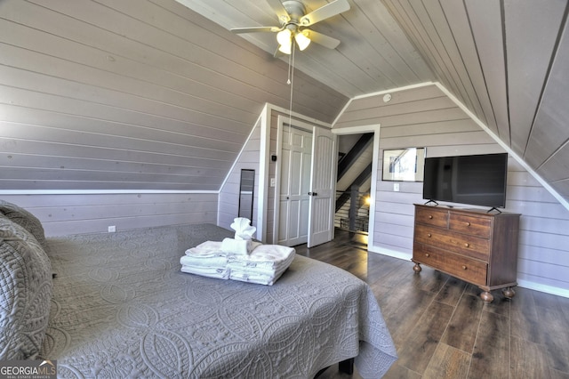bedroom featuring vaulted ceiling, wooden walls, and wood finished floors
