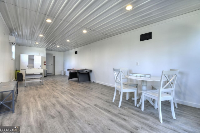 dining area featuring recessed lighting, an AC wall unit, baseboards, light wood finished floors, and visible vents