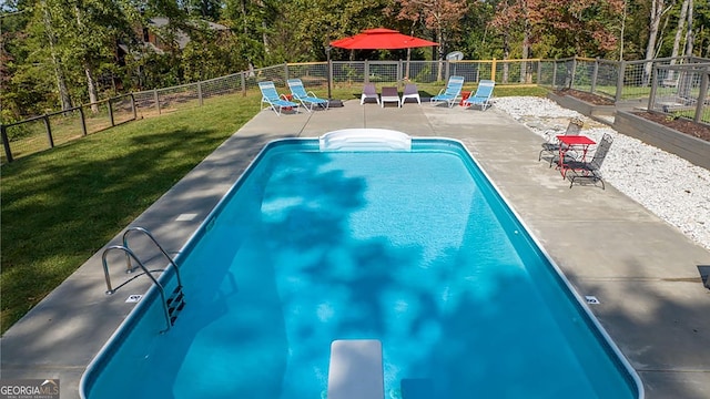 view of pool featuring a patio, a fenced in pool, a fenced backyard, a diving board, and a yard