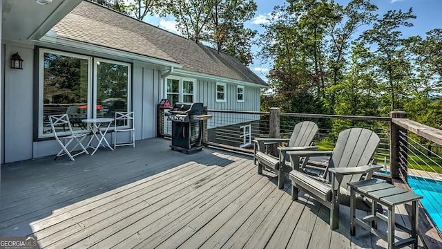 deck with grilling area and an outdoor pool