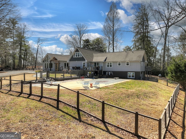 view of front of home featuring fence, a wooden deck, a patio, a pool, and a front yard