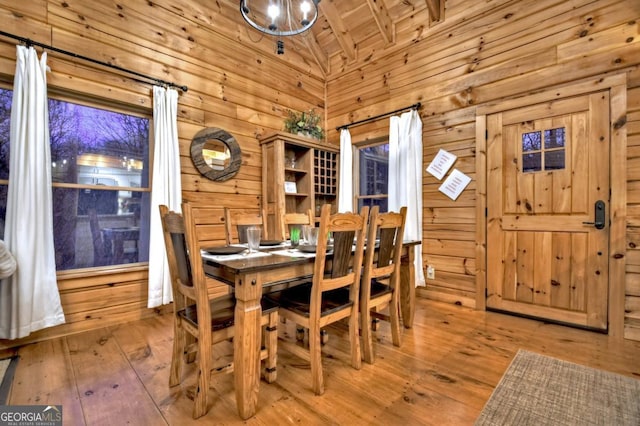 dining room with hardwood / wood-style floors, high vaulted ceiling, wooden ceiling, and wood walls