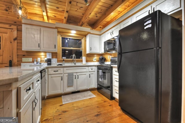 kitchen featuring beamed ceiling, light wood finished floors, a sink, black appliances, and wood ceiling