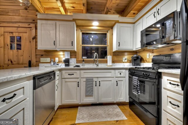 kitchen featuring light wood-type flooring, wood ceiling, a sink, beamed ceiling, and black appliances