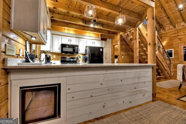 kitchen with white cabinetry, black appliances, wood ceiling, and wood walls