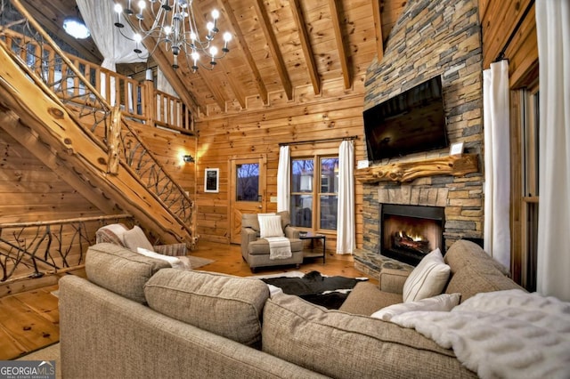 living room featuring stairs, wooden walls, wood finished floors, and wood ceiling