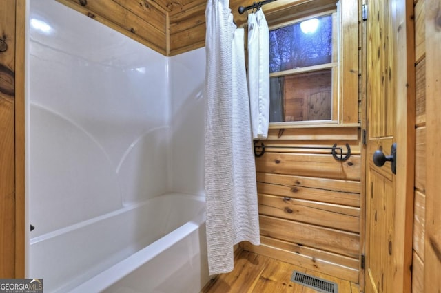 full bath featuring shower / tub combo with curtain, visible vents, and wood finished floors