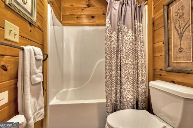 full bathroom with toilet, wood walls, and shower / bath combination with curtain
