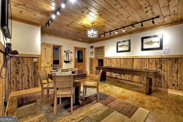 carpeted dining room featuring a wainscoted wall, wood ceiling, and wooden walls