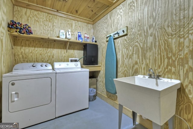 laundry area featuring wooden ceiling, a sink, laundry area, independent washer and dryer, and wallpapered walls
