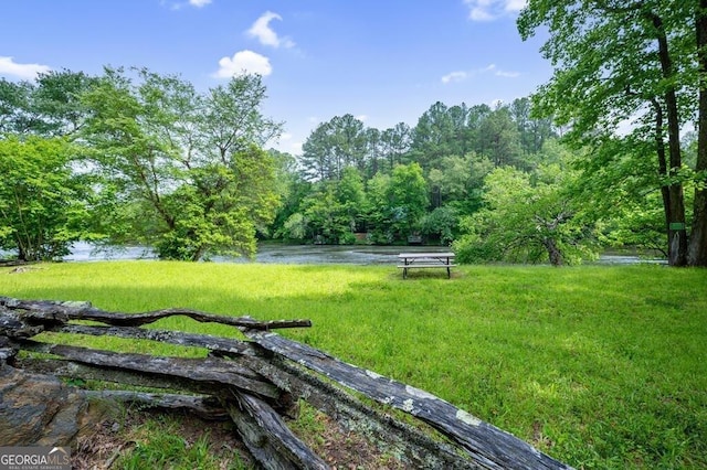 view of community featuring a water view and a yard