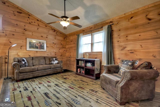 1301 Newport Dr, Ellijay, GA 30540 - living room featuring vaulted ceiling, ceiling fan, wood walls, and a textured ceiling