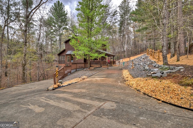 1301 Newport Dr, Ellijay, GA 30540 - rustic home featuring covered porch, a chimney, a view of trees, and driveway