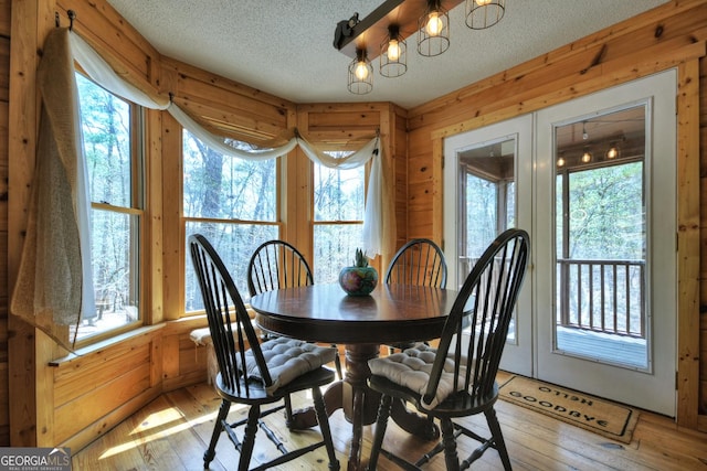 1301 Newport Dr, Ellijay, GA 30540 - dining space with a textured ceiling, light wood-style flooring, wooden walls, and a chandelier