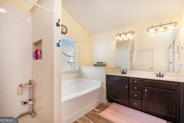 307 Montgomery Way, Woodstock, GA 30188 - bathroom with wood finished floors, a garden tub, tiled shower, double vanity, and vaulted ceiling