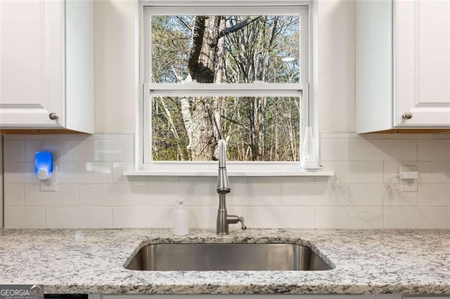 2374 Buchanan Hwy, Dallas, GA 30157 - kitchen with decorative backsplash, white cabinetry, a sink, and light stone countertops