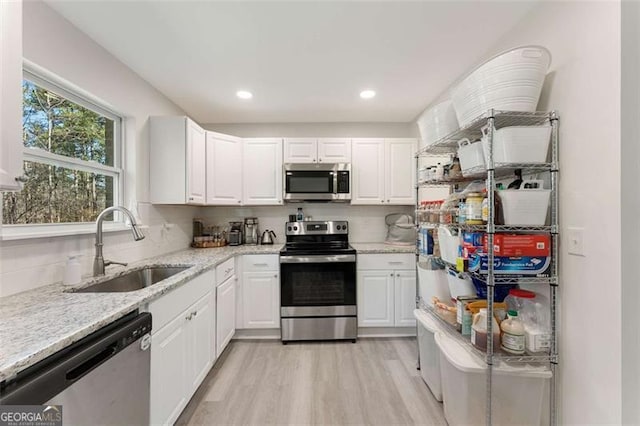 2374 Buchanan Hwy, Dallas, GA 30157 - kitchen with tasteful backsplash, stainless steel appliances, a sink, light wood-style floors, and white cabinets