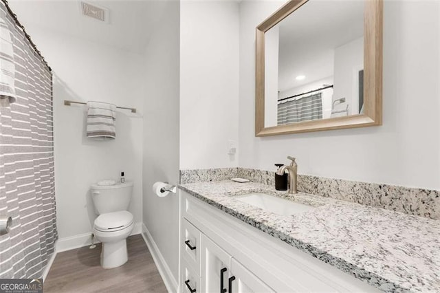 2374 Buchanan Hwy, Dallas, GA 30157 - full bathroom featuring toilet, vanity, wood finished floors, baseboards, and visible vents