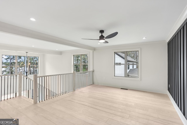spare room featuring visible vents, ceiling fan, light wood-style flooring, and plenty of natural light