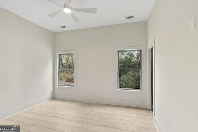 unfurnished room featuring baseboards, visible vents, light wood-style floors, and a ceiling fan