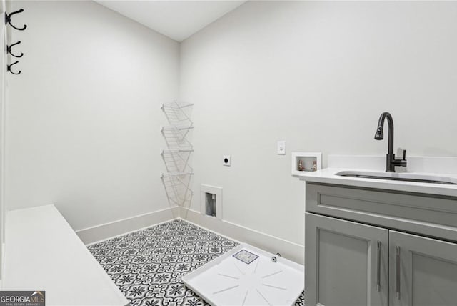 laundry area with a sink, hookup for an electric dryer, baseboards, cabinet space, and hookup for a washing machine