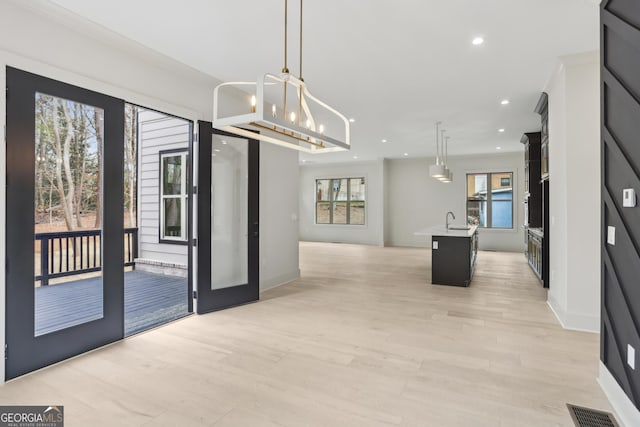 interior space featuring a chandelier, light wood-type flooring, baseboards, visible vents, and recessed lighting