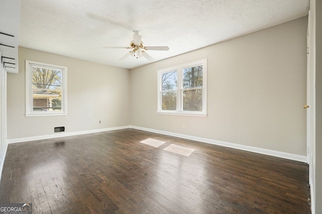 spare room featuring dark wood finished floors, baseboards, a textured ceiling, and a ceiling fan