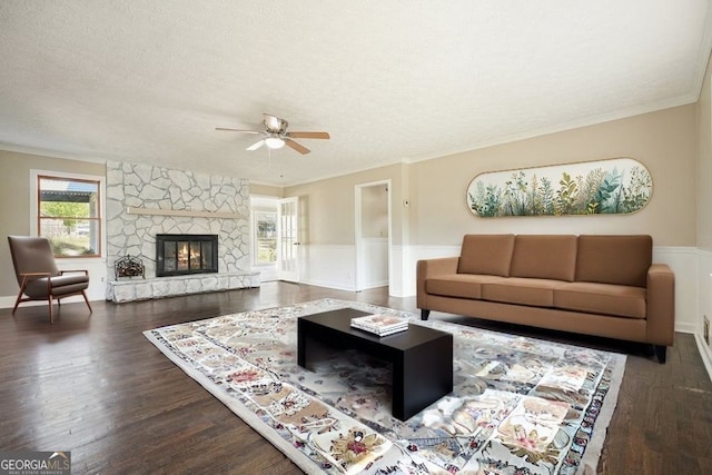 living area with a wealth of natural light, wainscoting, and a ceiling fan