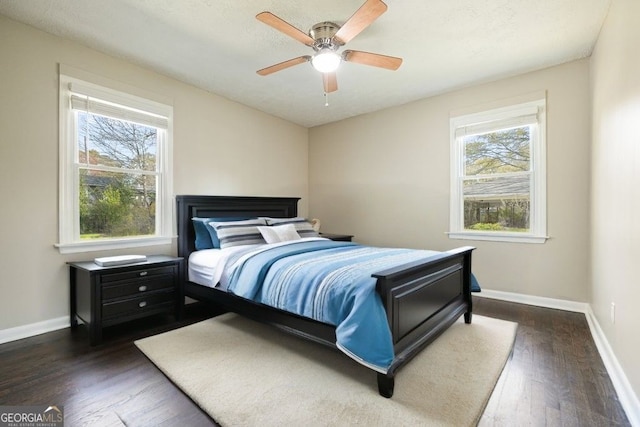 bedroom with baseboards, ceiling fan, and dark wood-style flooring