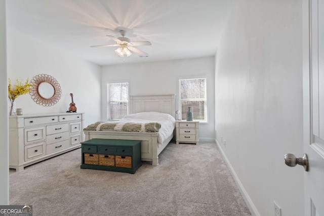 bedroom featuring light colored carpet, baseboards, and a ceiling fan