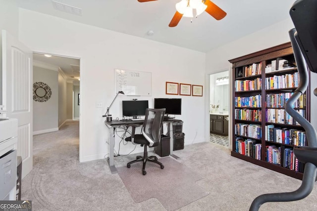 carpeted home office with baseboards, a ceiling fan, and visible vents