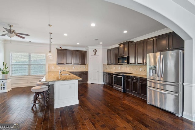 kitchen with crown molding, dark brown cabinetry, and stainless steel appliances