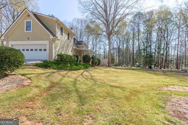 115 Flagstop Run, Fayetteville, GA 30215 - view of side of property with an attached garage, a yard, and stucco siding