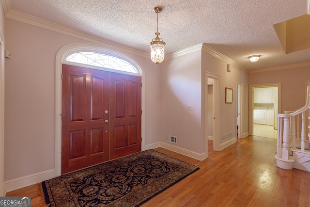 115 Flagstop Run, Fayetteville, GA 30215 - foyer with washer and dryer, a textured ceiling, light wood finished floors, ornamental molding, and stairway