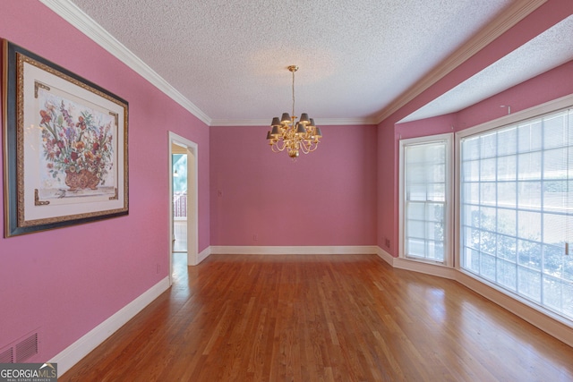 115 Flagstop Run, Fayetteville, GA 30215 - empty room featuring a textured ceiling, wood finished floors, a chandelier, and ornamental molding