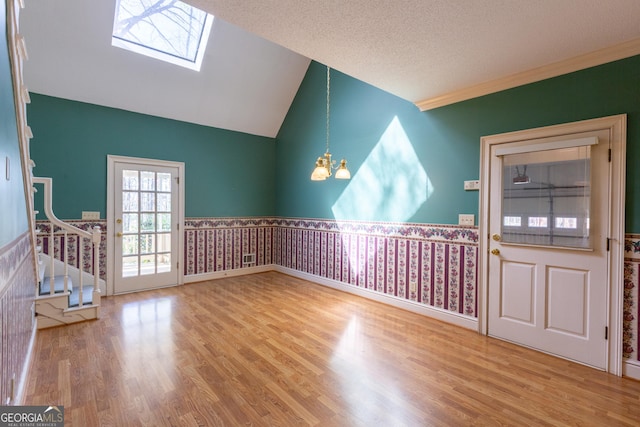 115 Flagstop Run, Fayetteville, GA 30215 - entrance foyer with a wainscoted wall, a skylight, wood finished floors, a chandelier, and vaulted ceiling