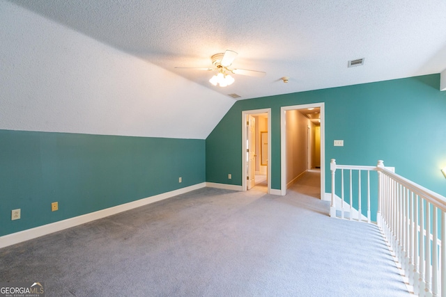 115 Flagstop Run, Fayetteville, GA 30215 - additional living space with ceiling fan, vaulted ceiling, carpet flooring, and a textured ceiling