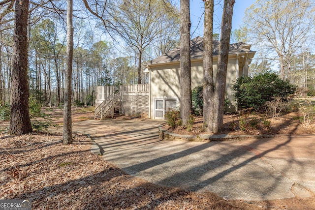 115 Flagstop Run, Fayetteville, GA 30215 - view of front of house with stairs, a wooden deck, and roof with shingles