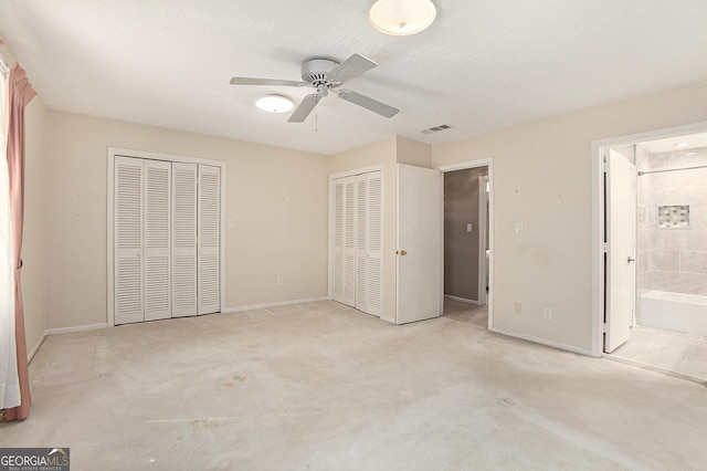 unfurnished bedroom with baseboards, visible vents, two closets, and ensuite bathroom