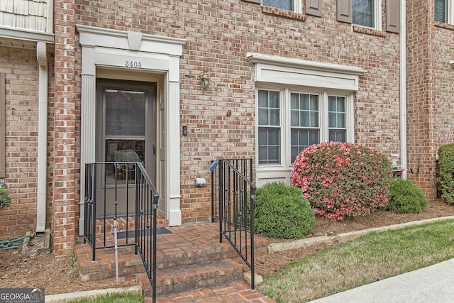 doorway to property featuring brick siding